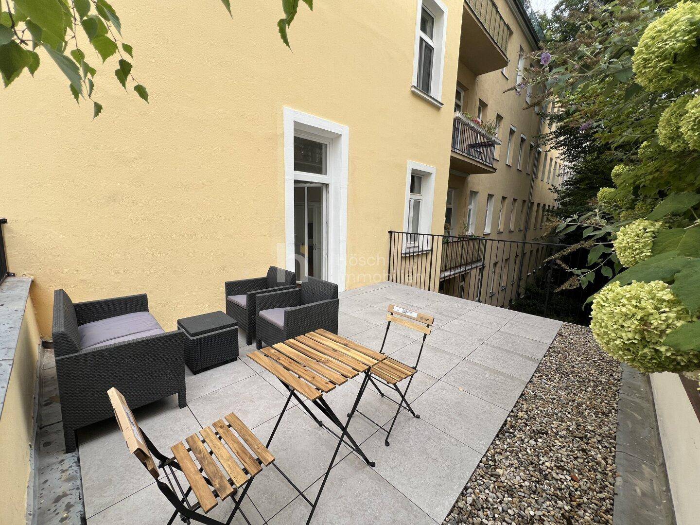Gemütliche Terrasse mit Sitzgelegenheiten und Blick auf die umliegende Bebauung.