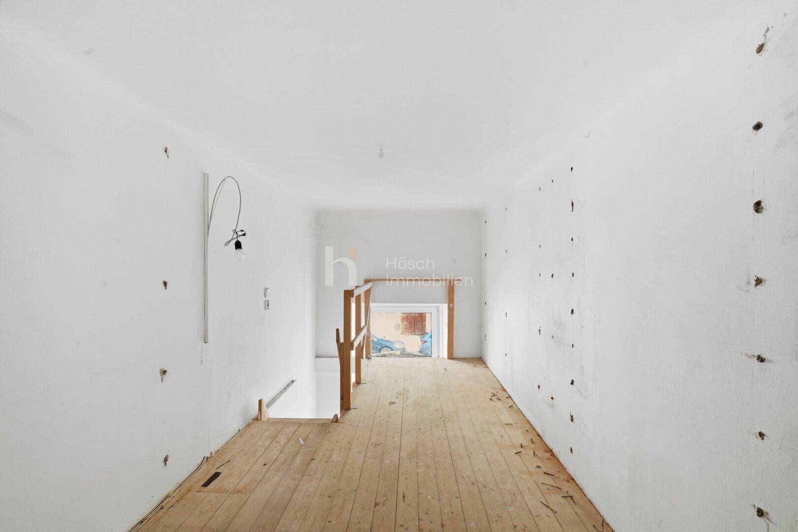 Unmöblierter Raum mit Holzdielenboden und Blick auf eine untere Ebene, ideal zur Neugestaltung.