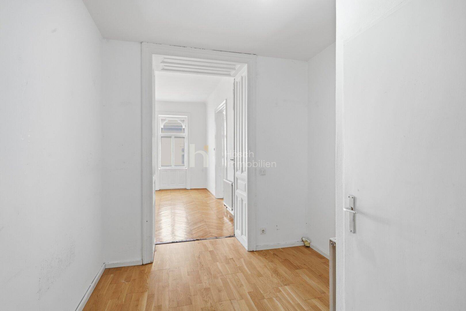 Heller Flur mit Parkettboden, der zu weiteren Zimmern der Wohnung führt.