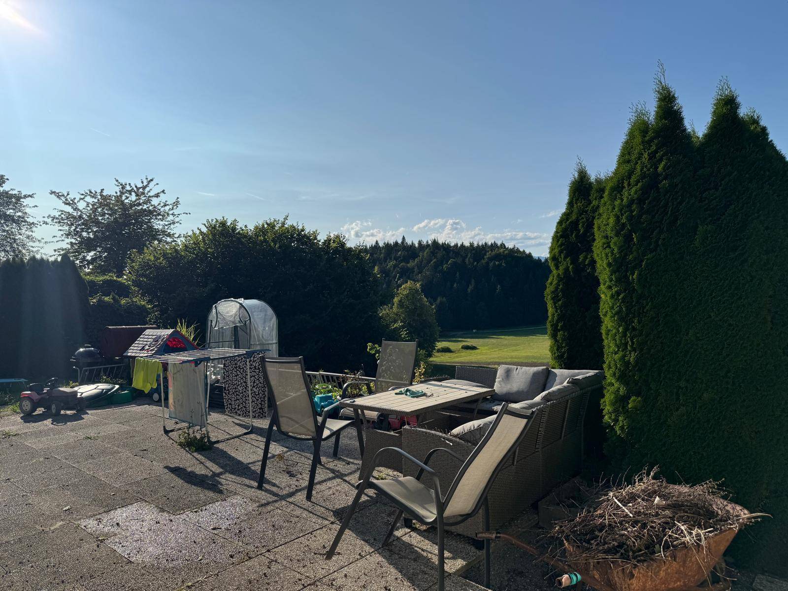 Geräumige Terrasse mit Gartenmöbeln und weitem Blick auf die umliegende grüne Landschaft.