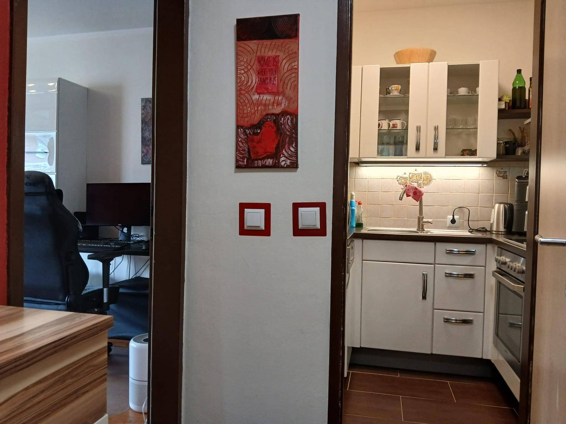 Flurbereich mit Blick in die angrenzende Küche und das Wohnzimmer. Die Türen sind offen und einladend.