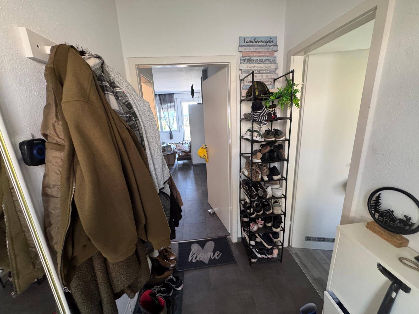Eingangsbereich mit Garderobe, Schuhregal und Blick in den Wohnbereich.