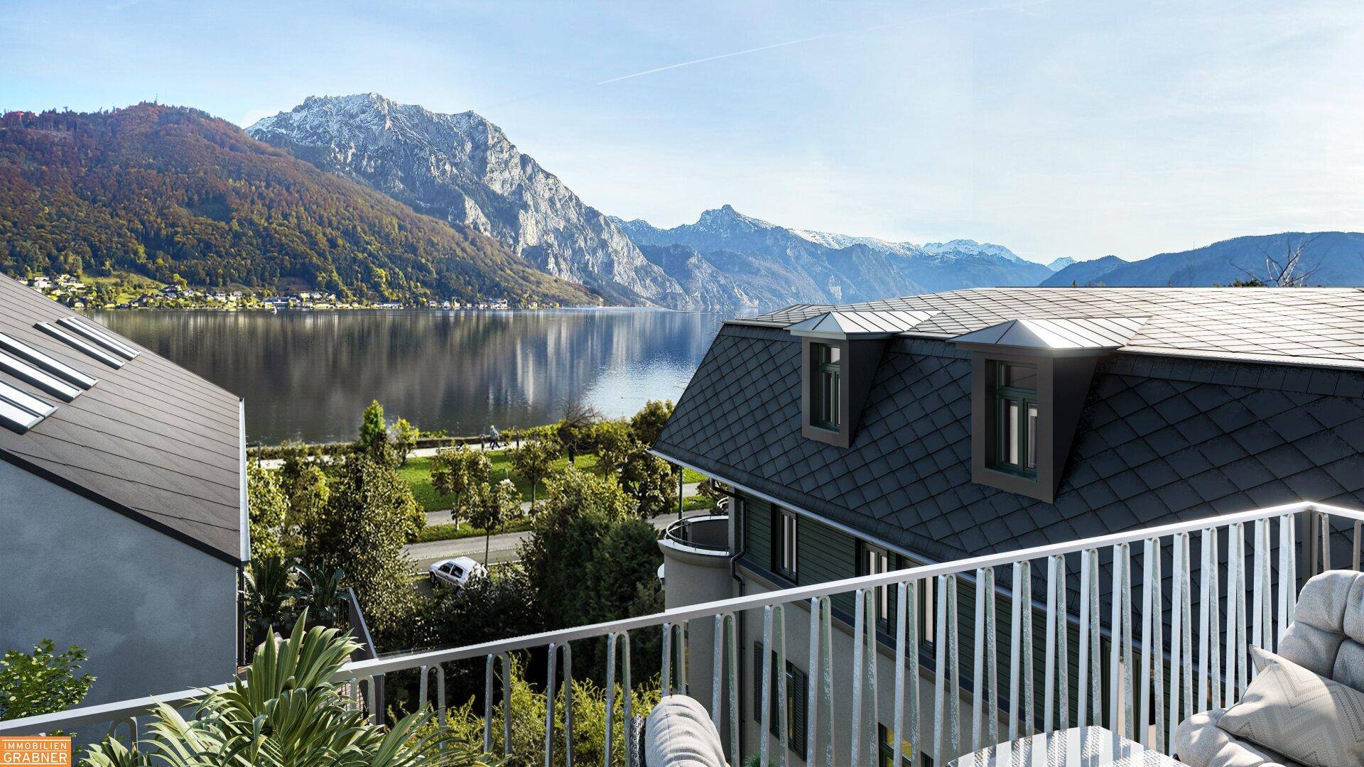 Blick vom Balkon auf den See und die umliegenden Berge mit bequemen Sitzgelegenheiten.