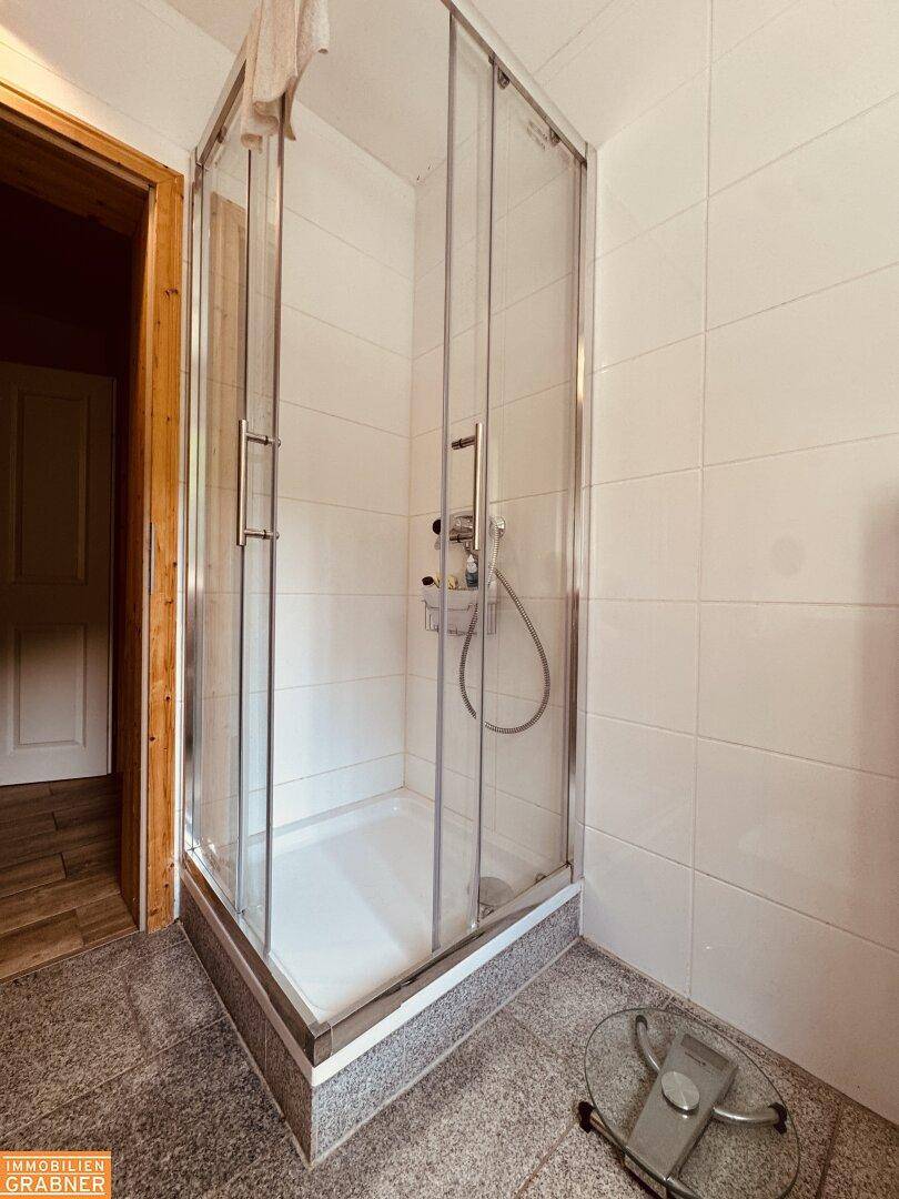 Badezimmer mit Duschkabine und Granitboden, bereit für die weitere Einrichtung.