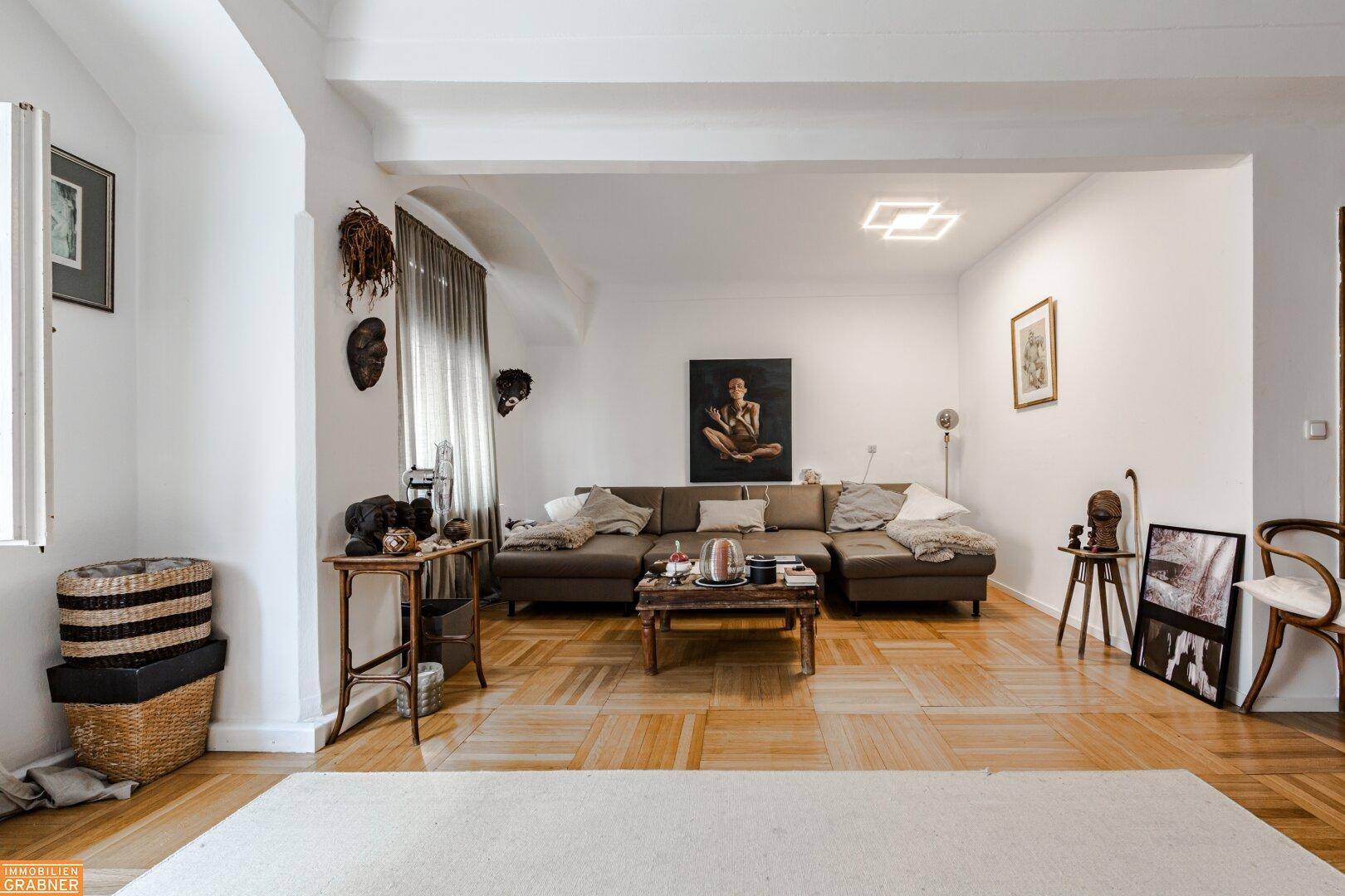 Helles Wohnzimmer mit modernem Sofa, Parkettboden und minimalistischer Dekoration.