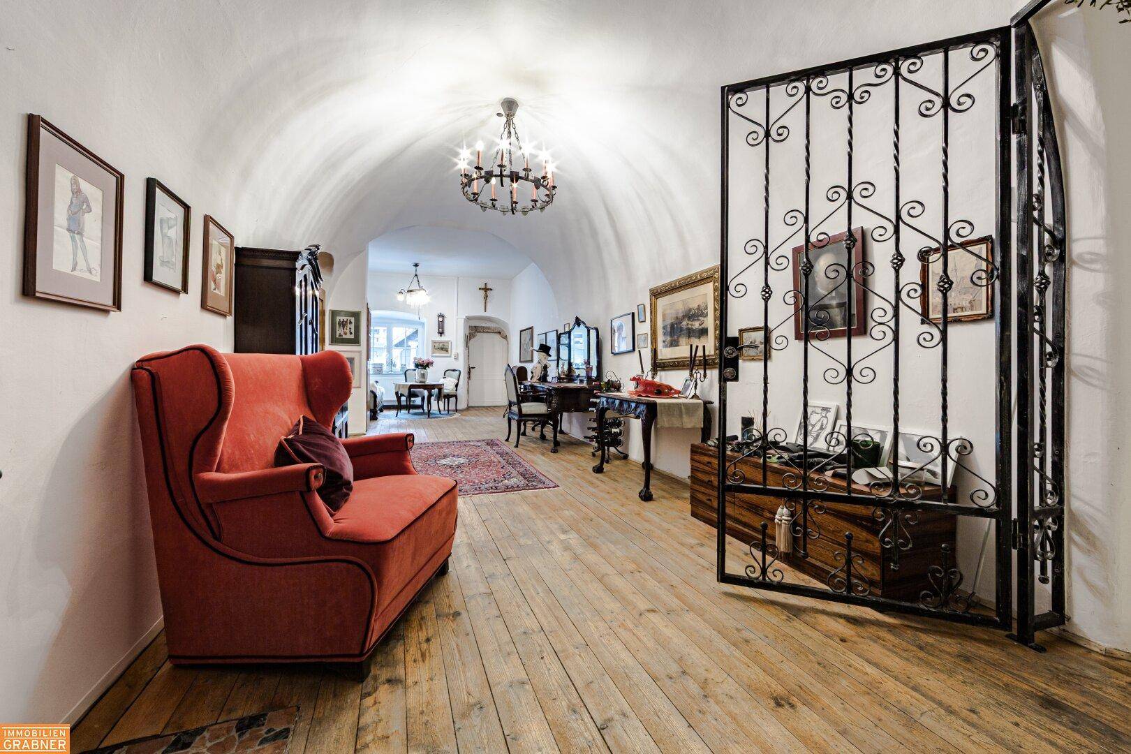 Eleganter Flur mit gewölbter Decke, Holzboden und schmiedeeisernem Tor.