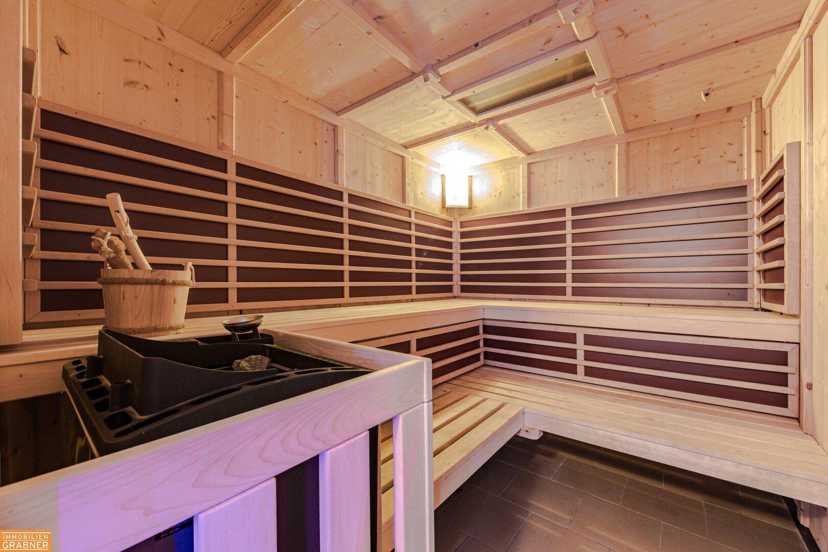 Moderne Holzsauna mit Bänken und Heizofen, bereit zur Entspannung.