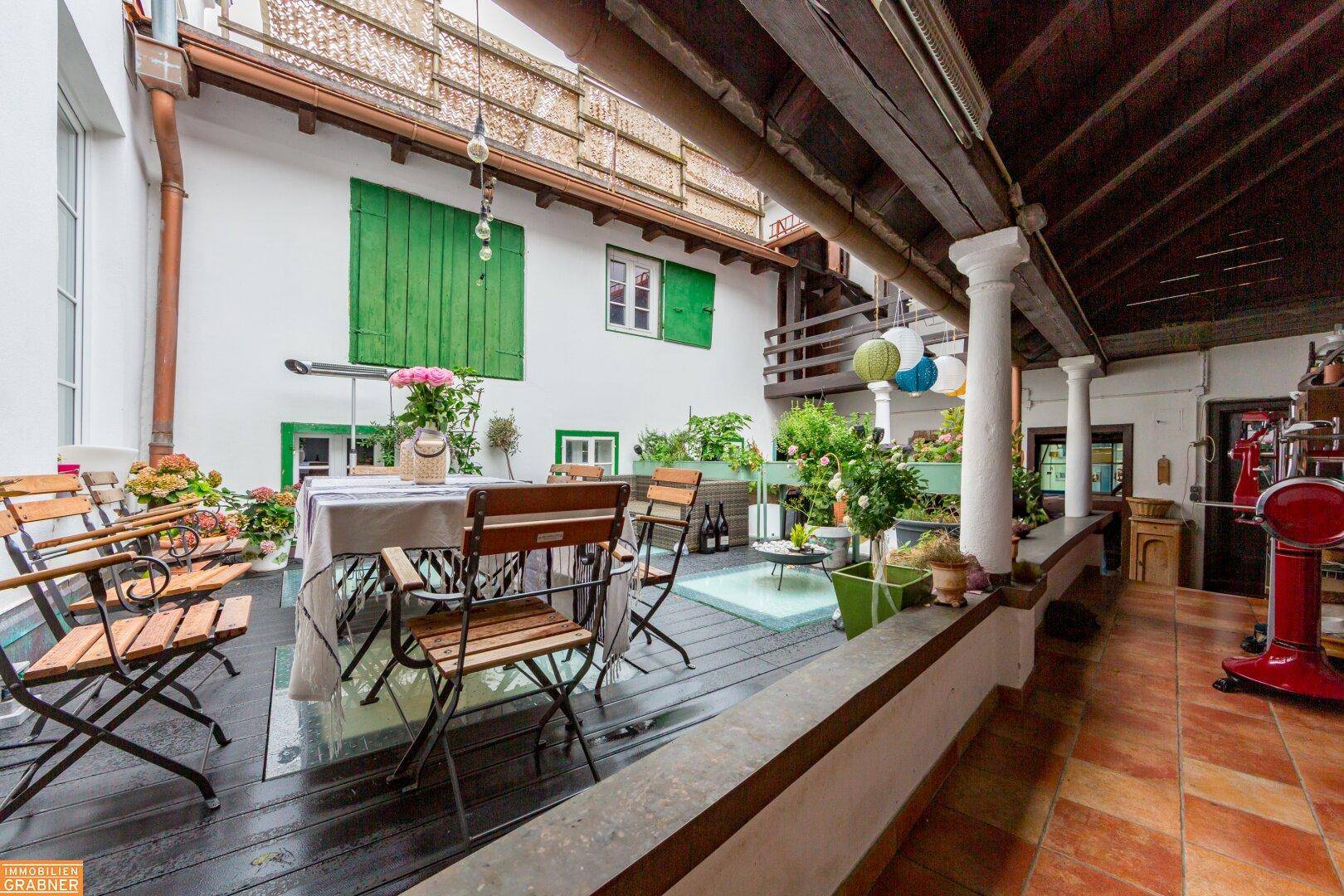 Große Terrasse mit Essbereich, Lounge-Möbeln und überdachtem Bereich.