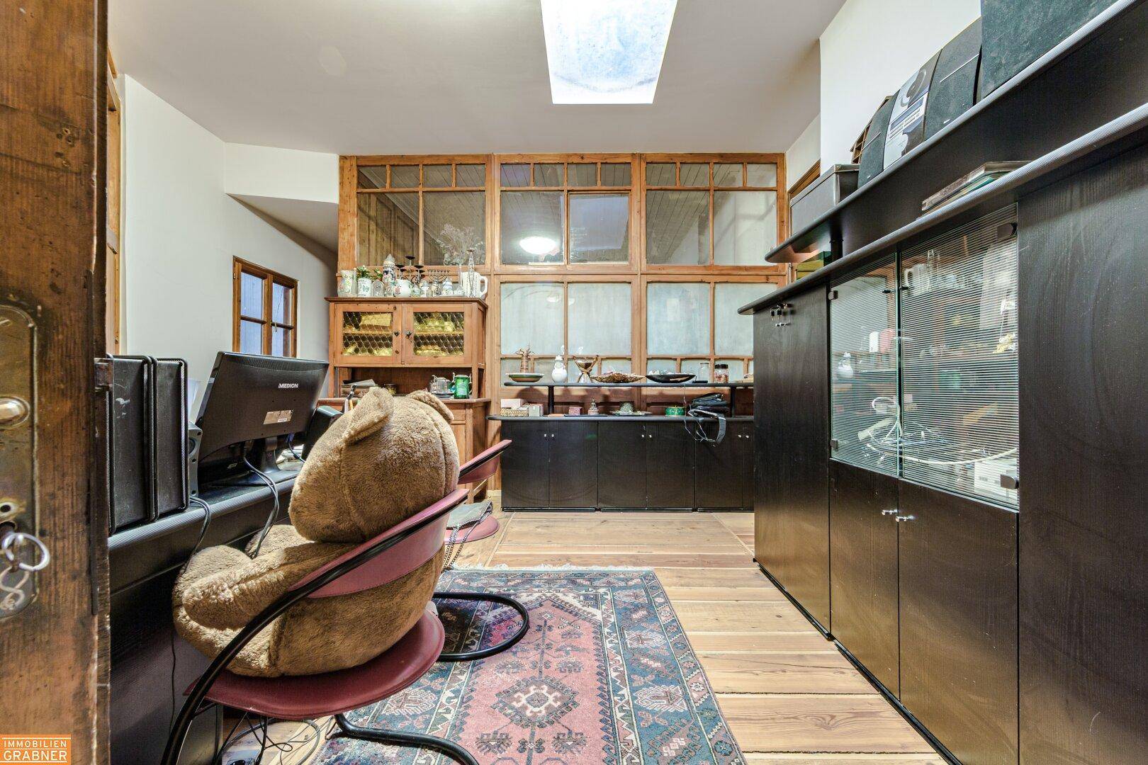 Arbeitszimmer mit Holzboden, Holzvertäfelung und Schreibtisch, ideal für konzentriertes Arbeiten.