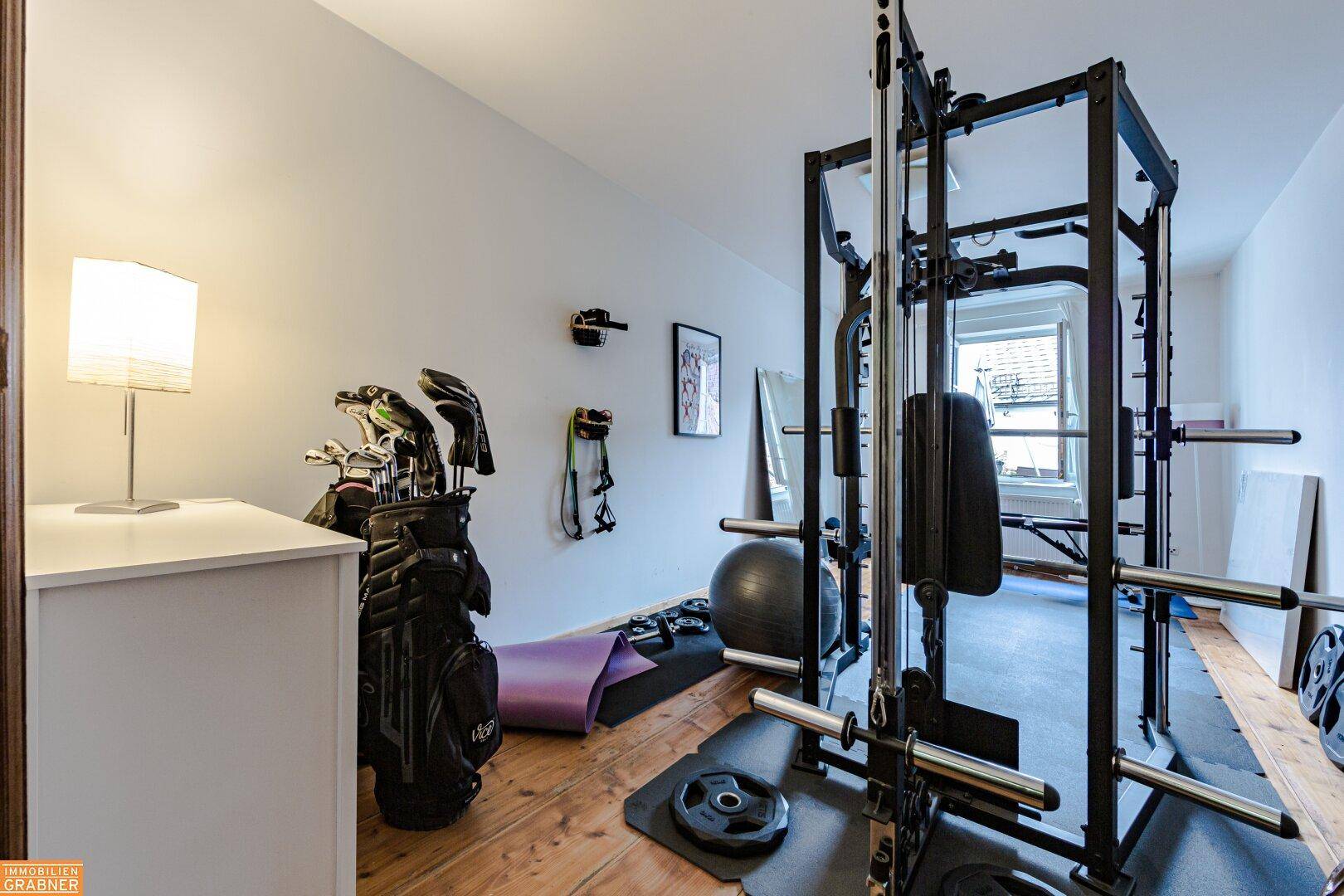 Fitnessraum mit Holzboden und verschiedenen Trainingsgeräten, ideal für das tägliche Workout.