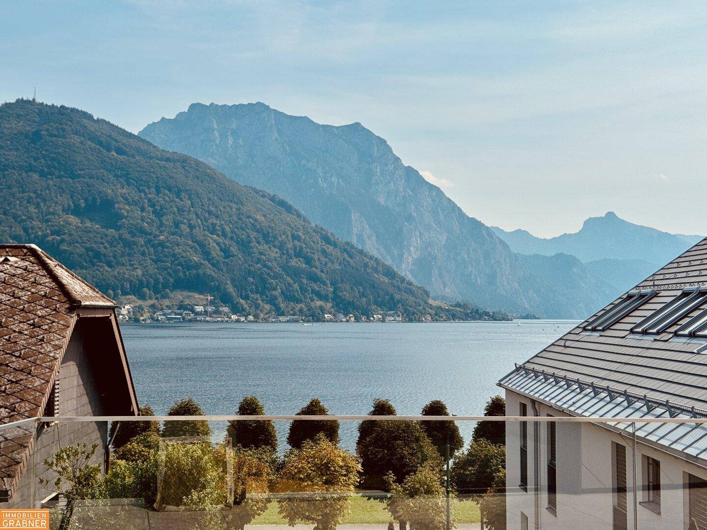 Atemberaubender Ausblick von der Terrasse auf den glitzernden See und die majestätischen Berge.