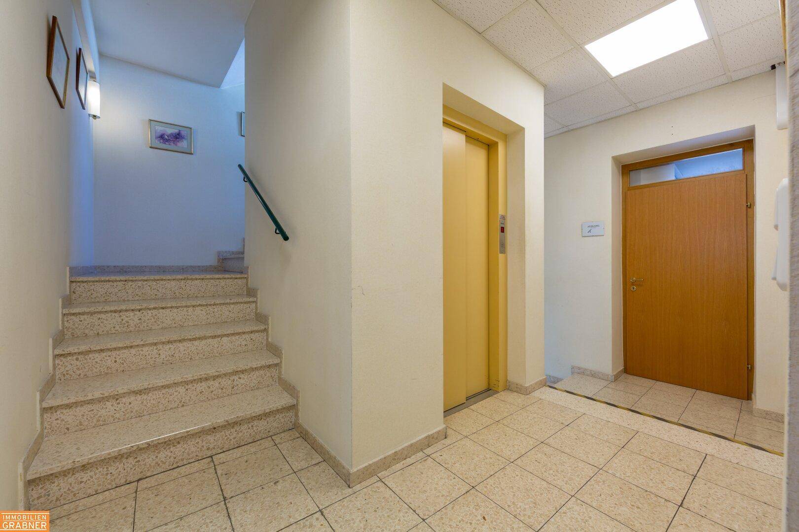 Eingangsbereich mit Treppe, Aufzug und Zugang zu den verschiedenen Büroeinheiten.