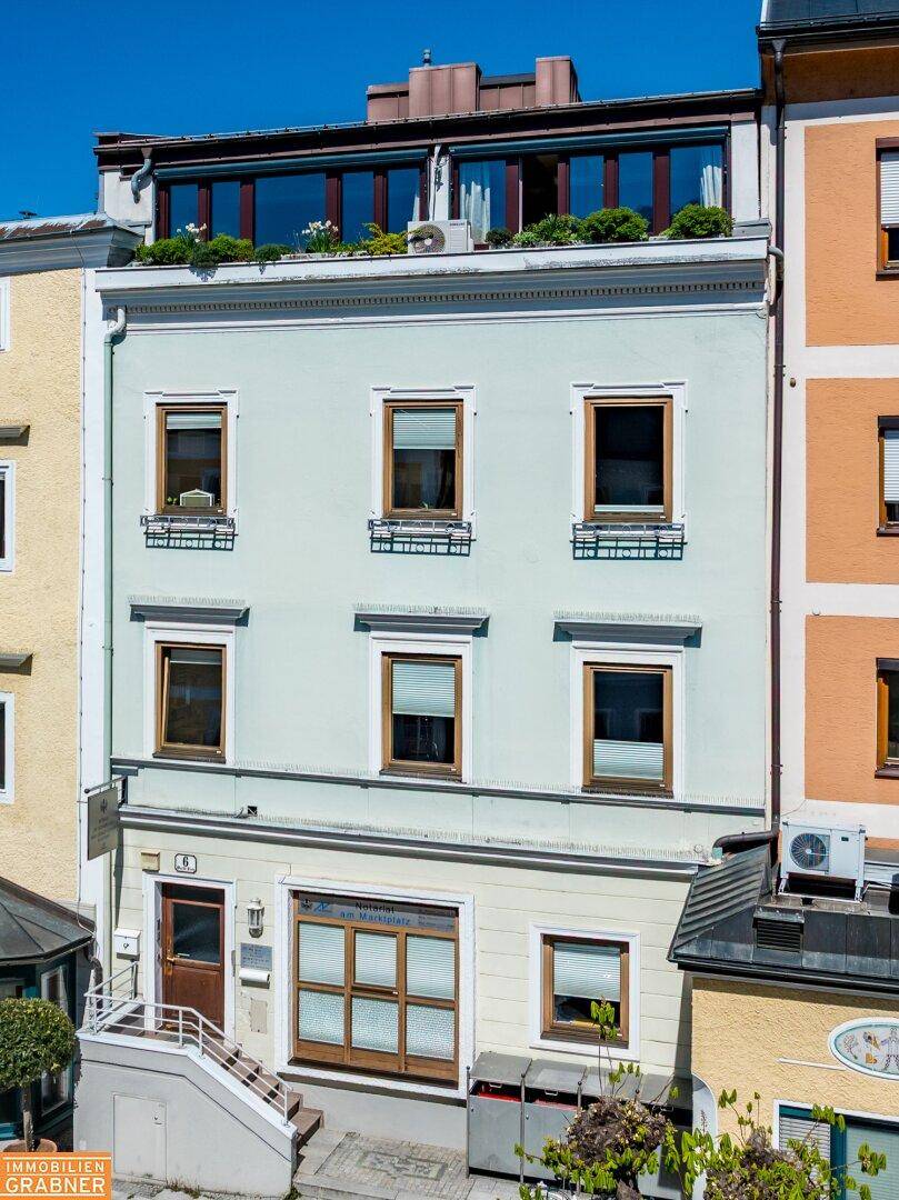 Historisches Gebäude mit heller Fassade und modernen Fenstern im Dachgeschoss.