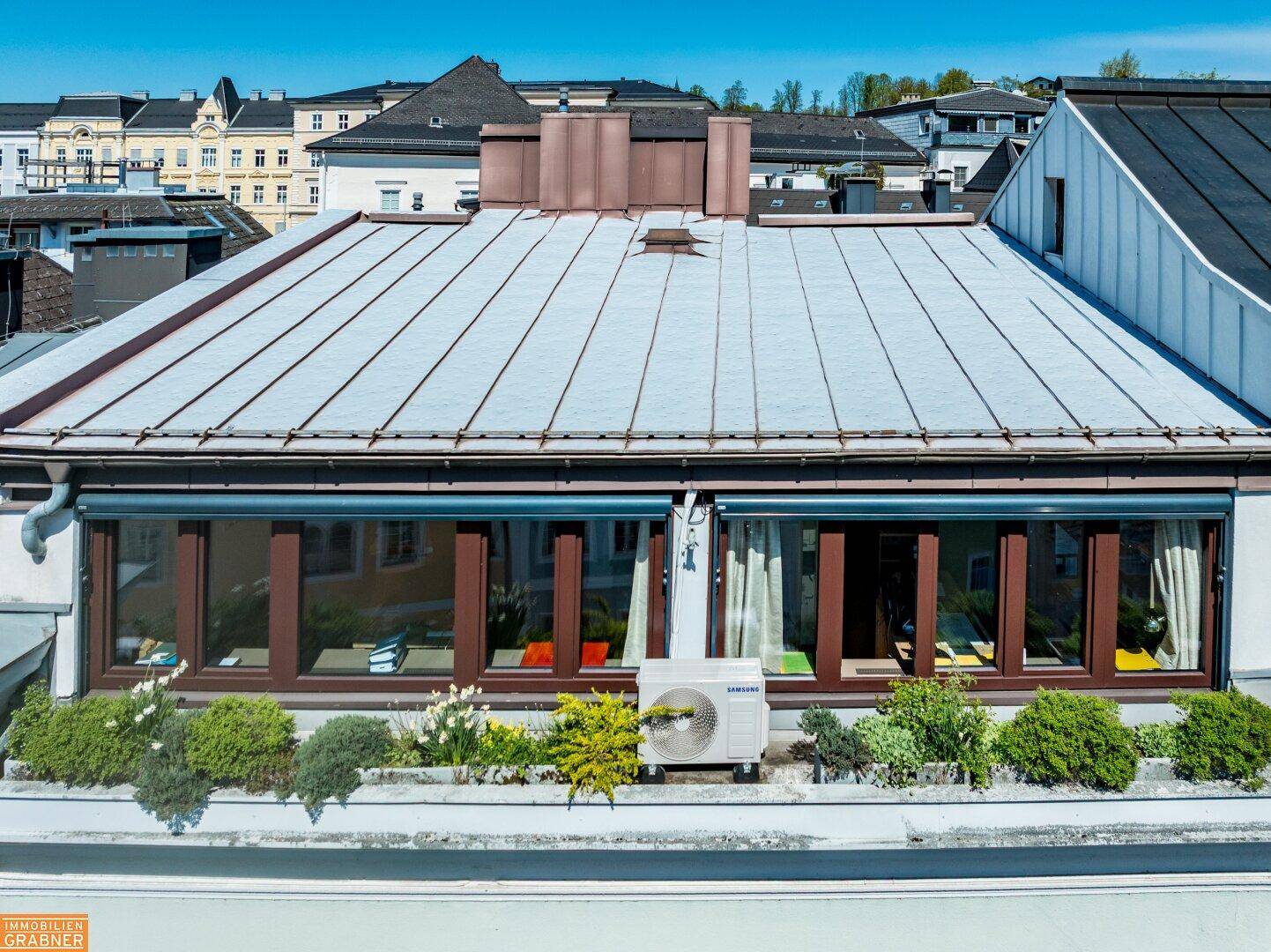 Dachterrasse mit Pflanzenkübeln und Blick auf die Umgebung.
