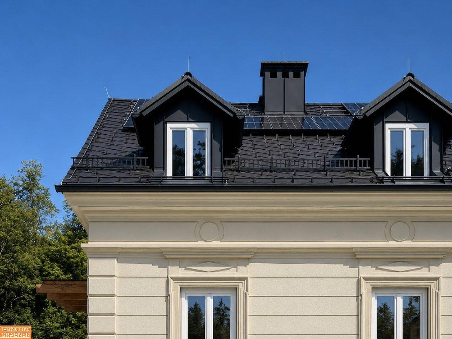 Detailansicht des Daches einer Villa mit Gaubenfenstern und installierten Solarpaneelen.