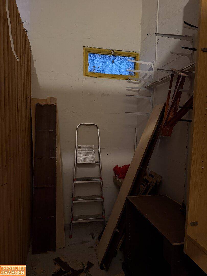 Kellerraum mit Holzverkleidung, Regalen und einem kleinen Fenster für natürliches Licht.