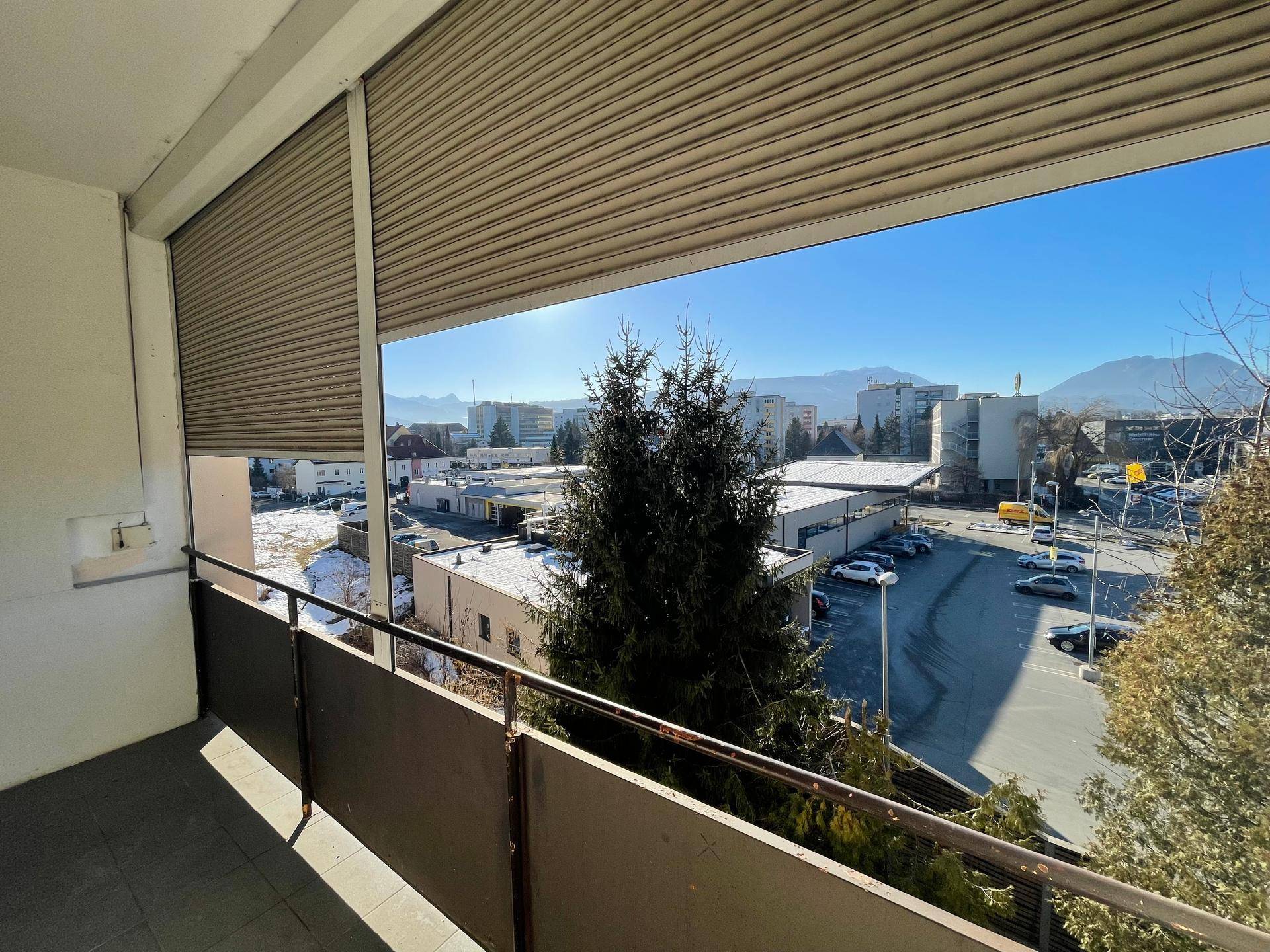 Geräumiger Balkon mit weitem Blick über die Stadt und die umliegende Berglandschaft.