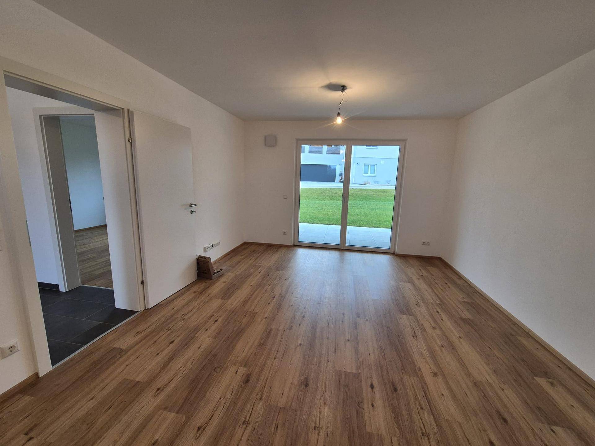 Helles Wohnzimmer mit Laminatboden und direktem Zugang zur Terrasse oder zum Garten.