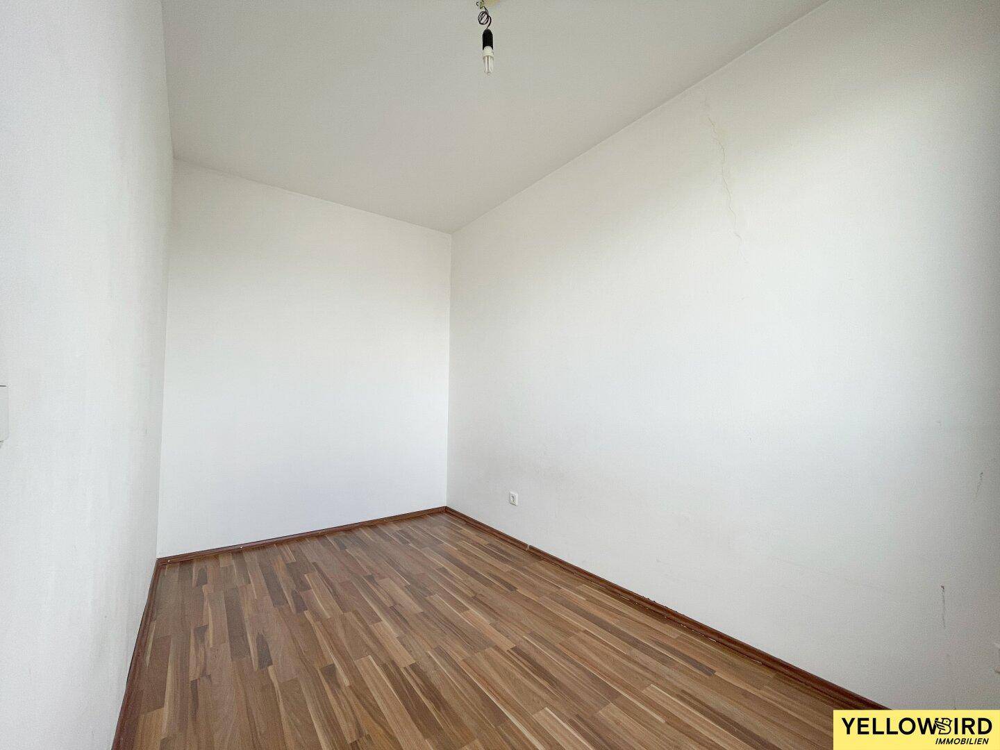 Kleiner, heller Raum mit Parkettboden und weißen Wänden, ideal als Schlaf- oder Arbeitszimmer.