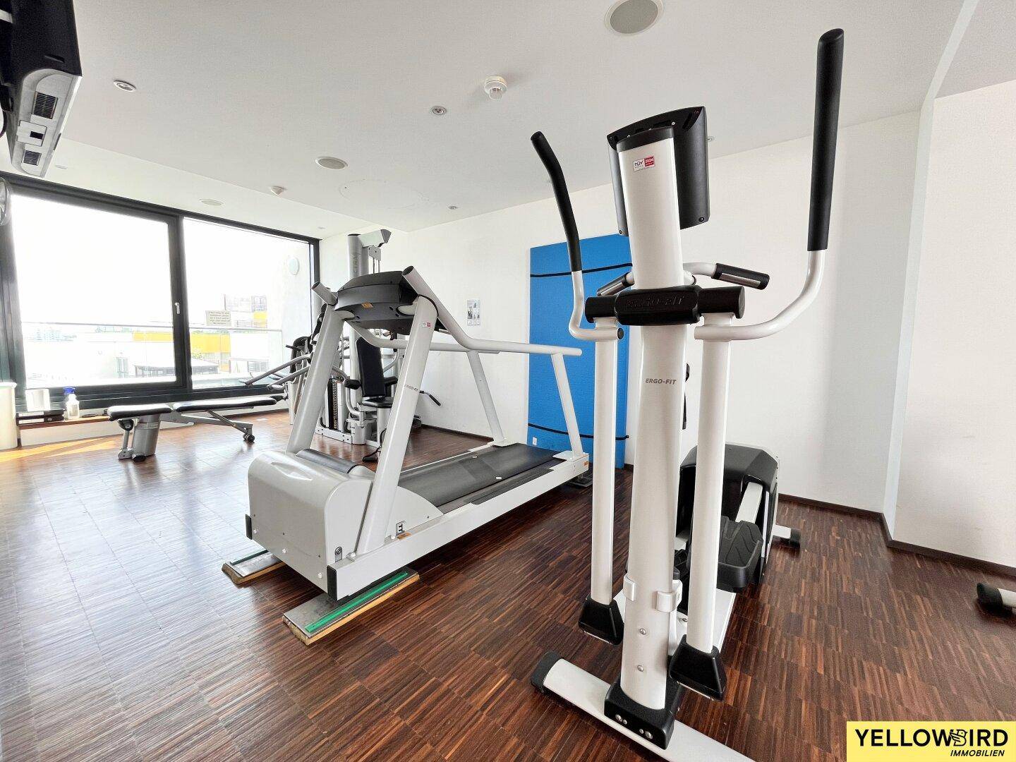 Gut ausgestatteter Fitnessraum mit Laufband und Crosstrainer für die Bewohner des Gebäudes.