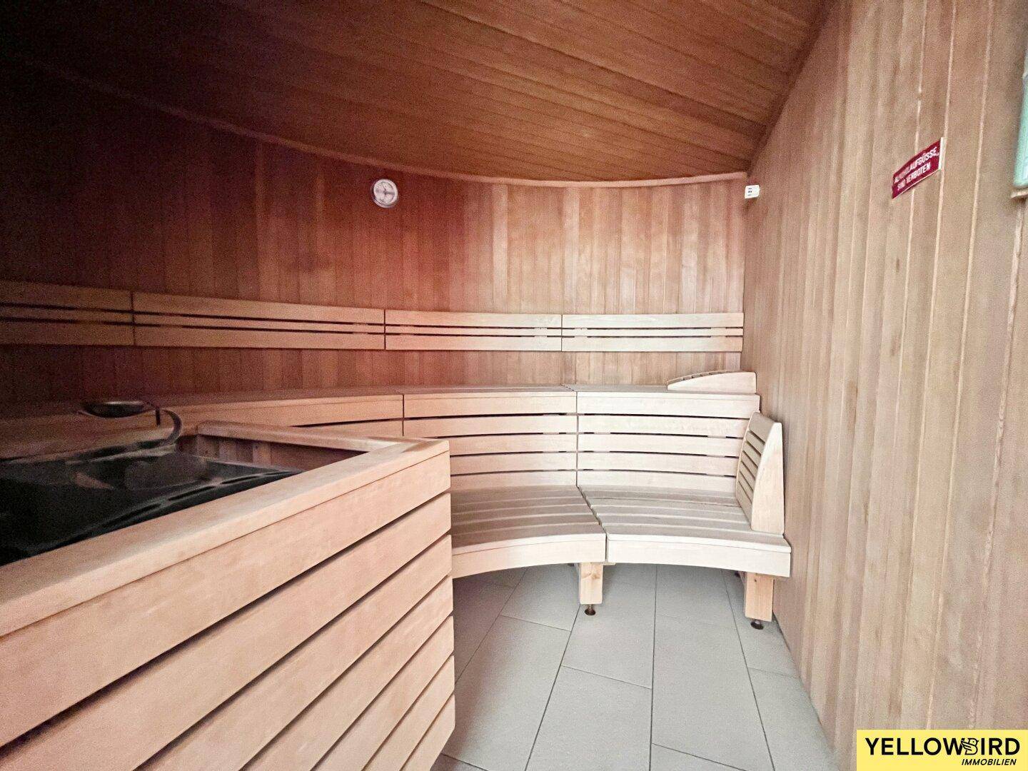 Gemütliche Sauna mit Holzverkleidung und bequemen Bänken, Teil des Wellnessbereichs.