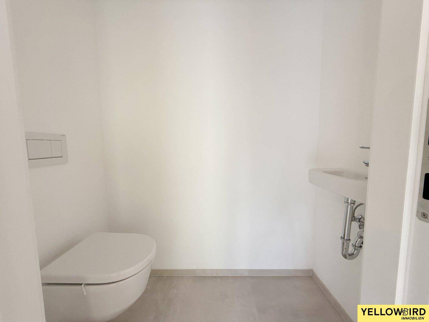 Helles Gäste-WC mit wandhängender Toilette und kleinem Waschbecken.