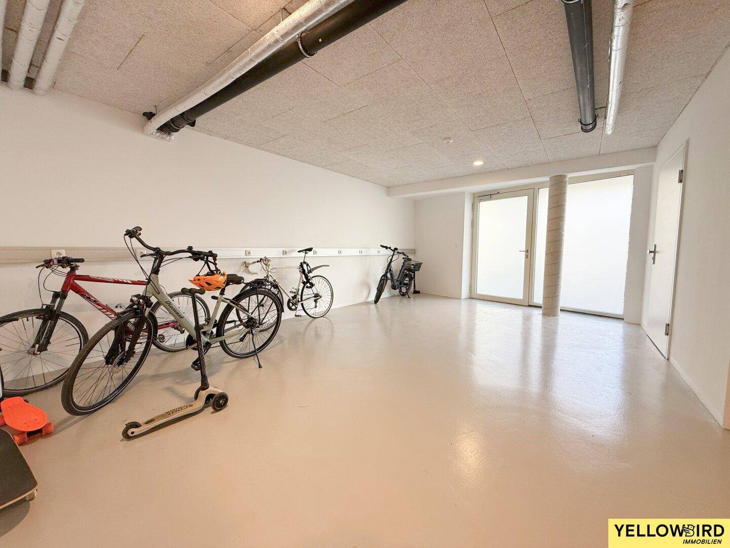 Geräumiger Fahrradraum mit mehreren Fahrrädern und einem Roller, ideal zur Aufbewahrung.