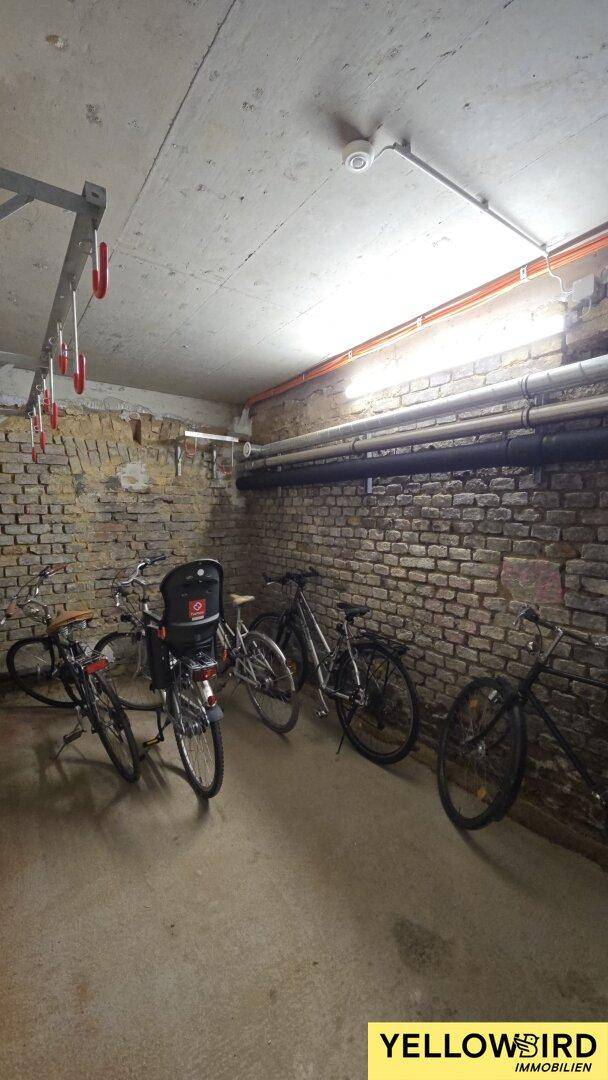 Fahrradraum im Keller mit Ziegelwänden und praktischen Aufhängungen für Fahrräder.