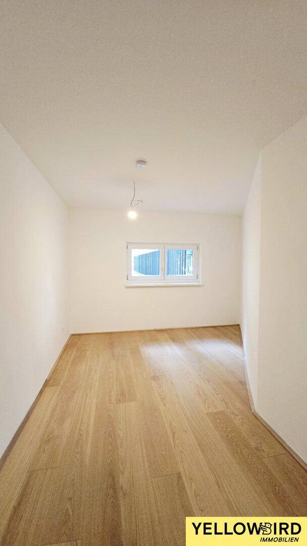 Helles Zimmer mit Holzboden und Fenster, ideal als Schlaf- oder Arbeitszimmer.