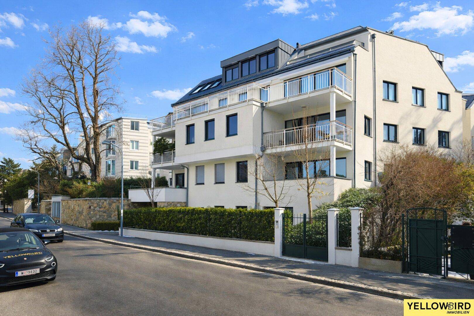 Attraktives Mehrfamilienhaus mit moderner Architektur und gepflegter Außenanlage an einer ruhigen Straße.