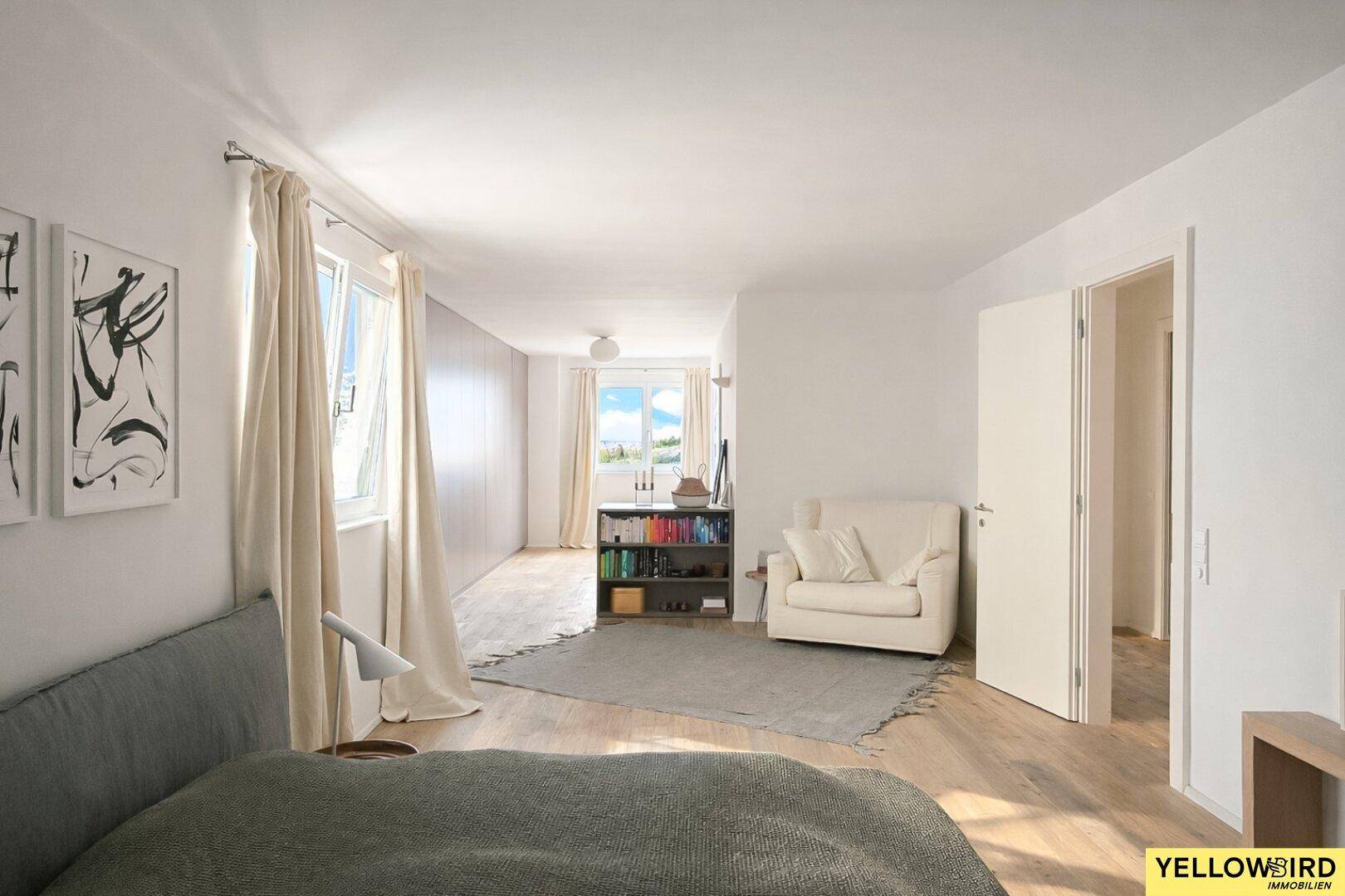 Helles Schlafzimmer mit Holzboden und großen Fenstern, bietet viel Tageslicht und eine ruhige Atmosphäre.