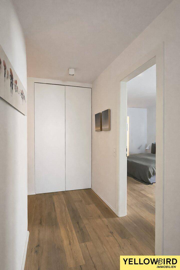 Schlichter Flur mit Holzboden und integrierten Schränken, bietet praktischen Stauraum.