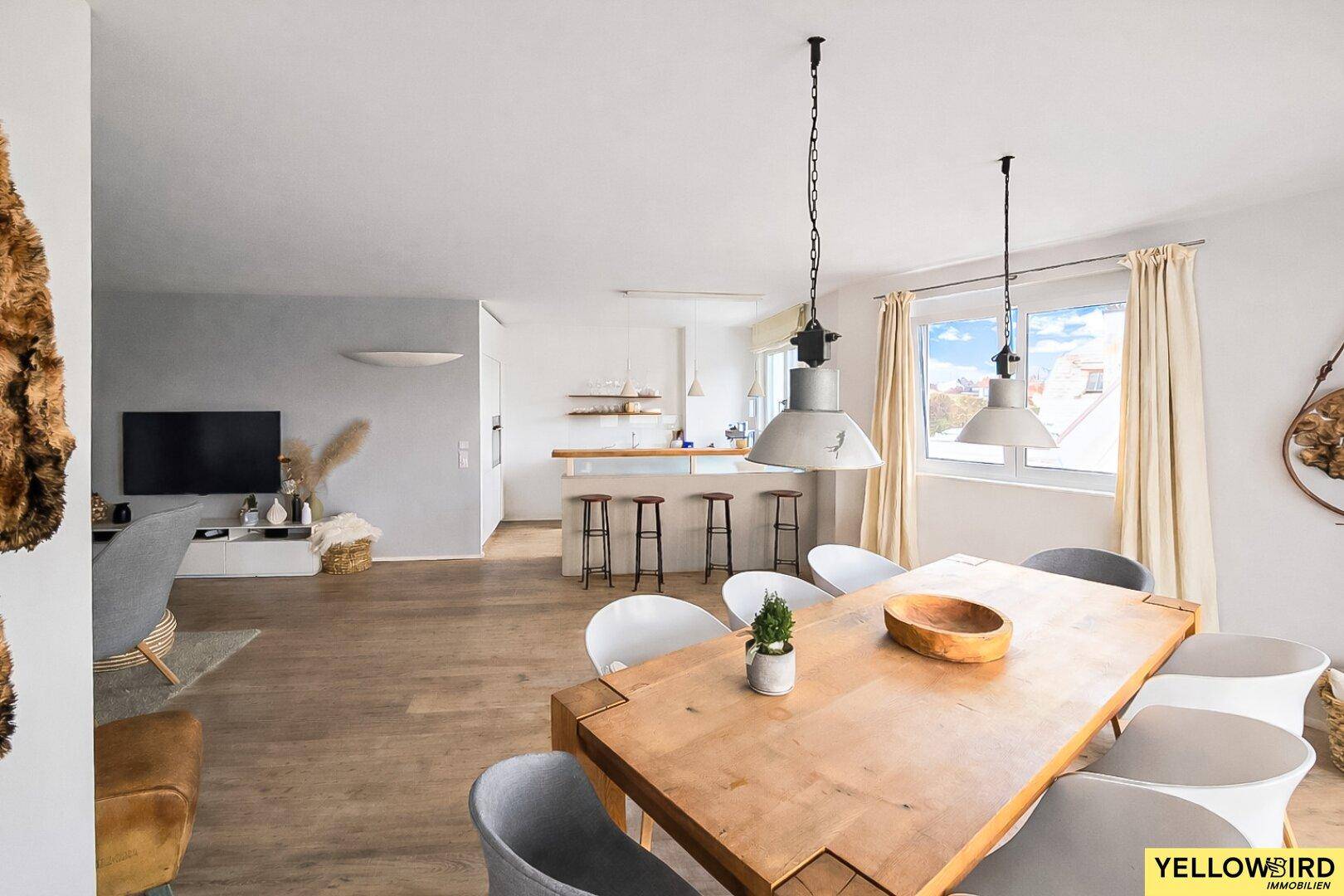 Heller offener Wohn- und Essbereich mit Holzboden und moderner Einrichtung, ideal für geselliges Beisammensein.