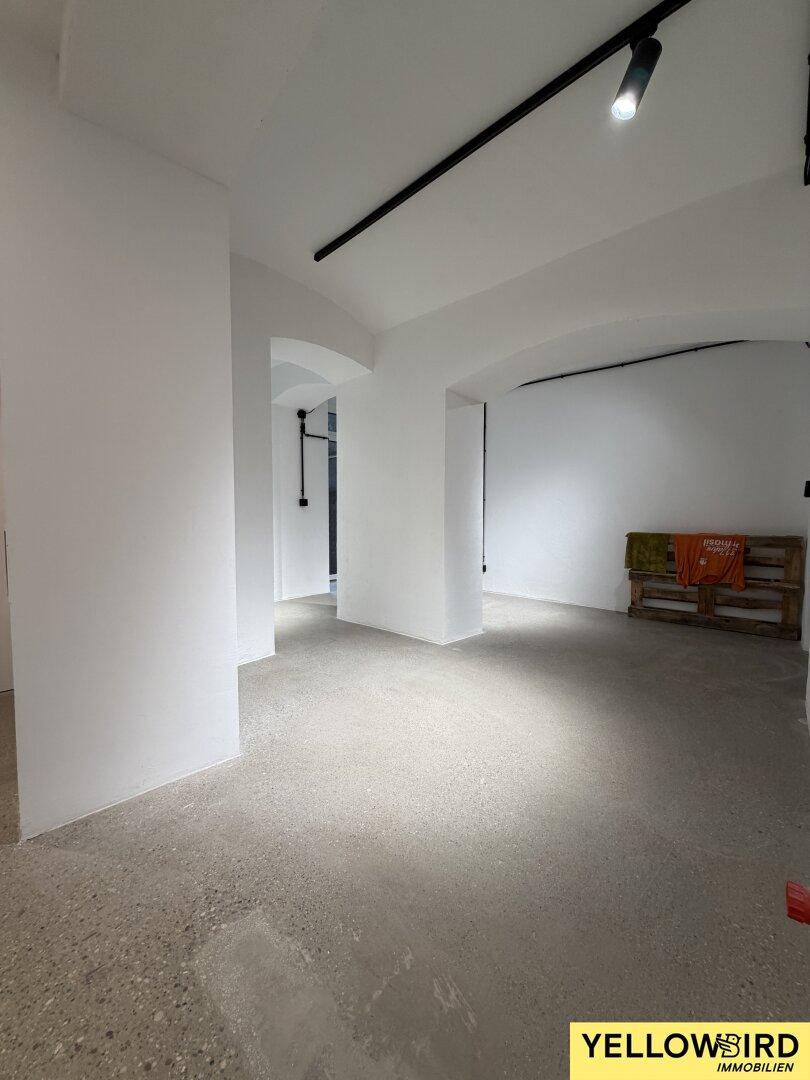 Weitläufiger Gewerberaum mit hohen Gewölbedecken und Betonboden, bereit für individuelle Gestaltung.