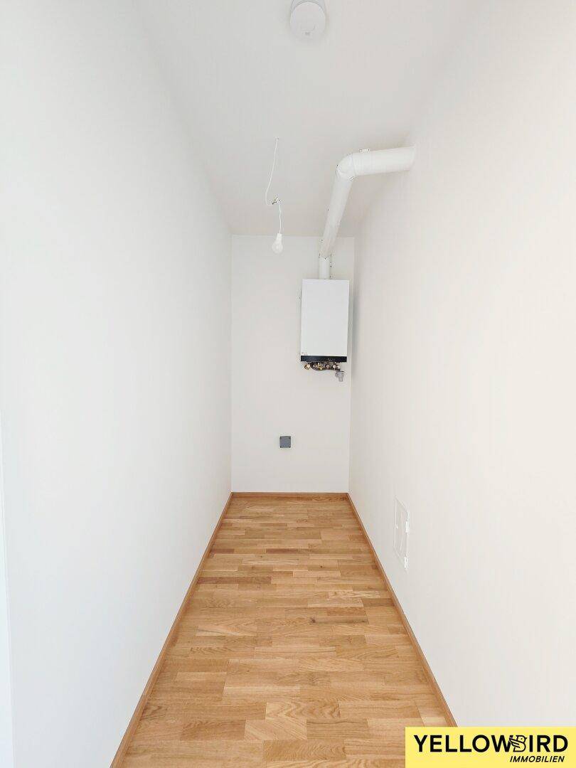 Praktischer Abstellraum mit Holzboden und Heizungsanlage.