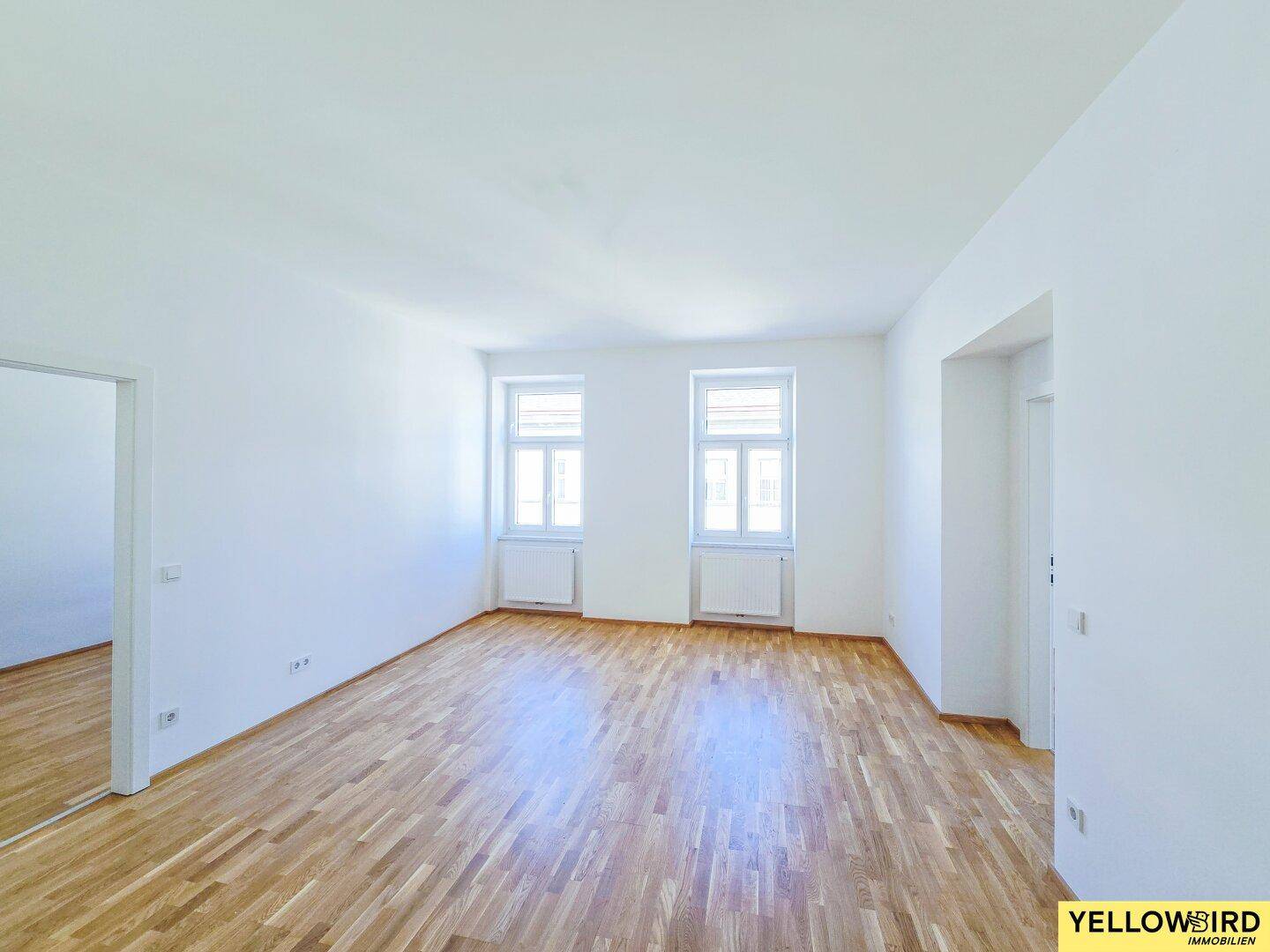 Lichtdurchflutetes Zimmer mit zwei Fenstern und Parkettboden, bietet viel Potenzial für individuelle Einrichtung.