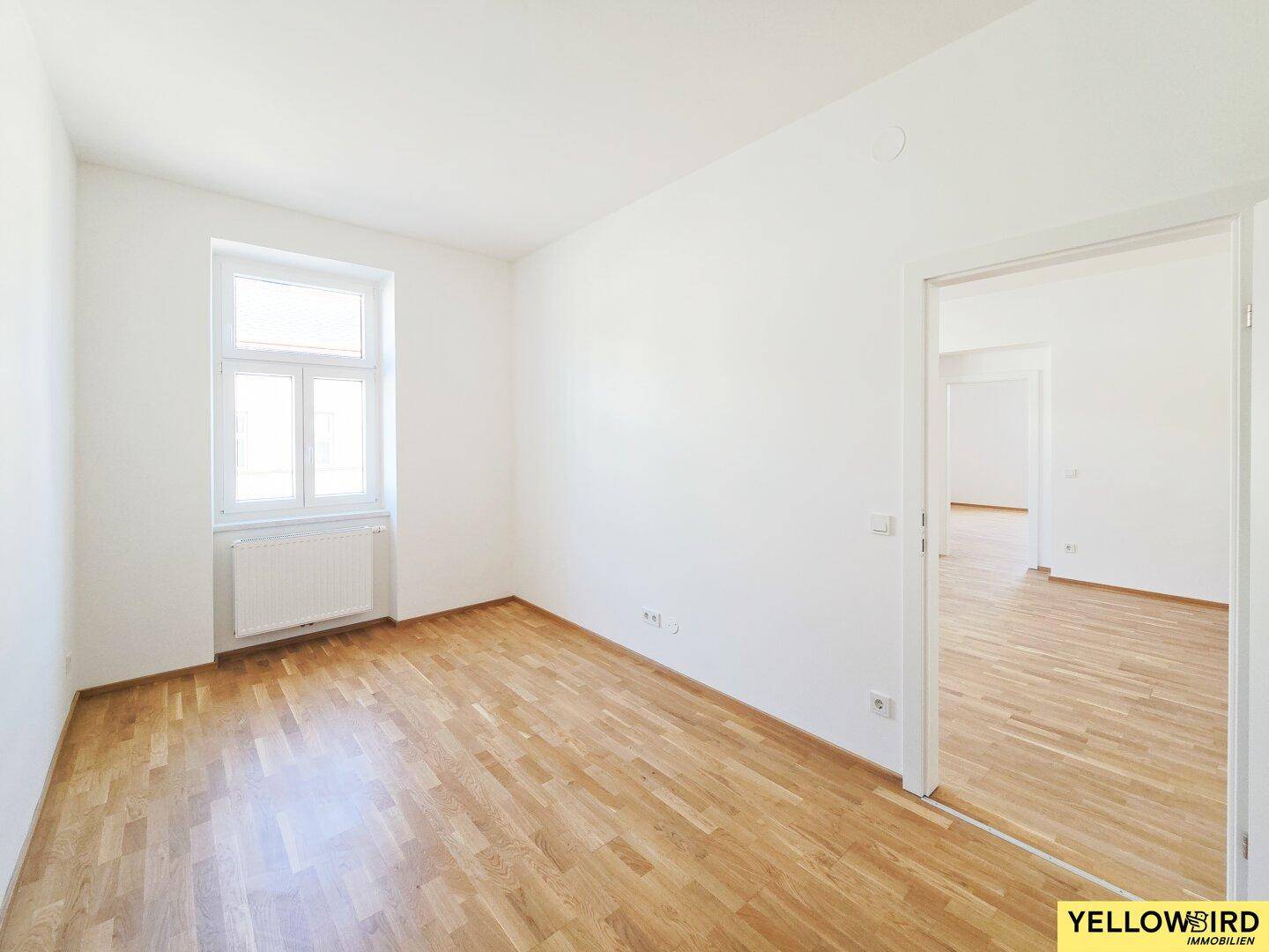 Ruhiges, helles Zimmer mit Parkettboden und einem Fenster, ideal als Schlaf- oder Arbeitszimmer.