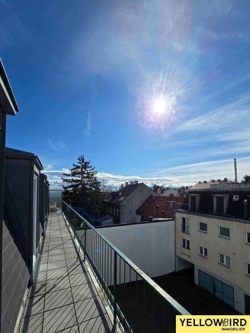 Sonniger Balkon mit weitem Blick über die Dächer der Stadt und die umliegende Landschaft.