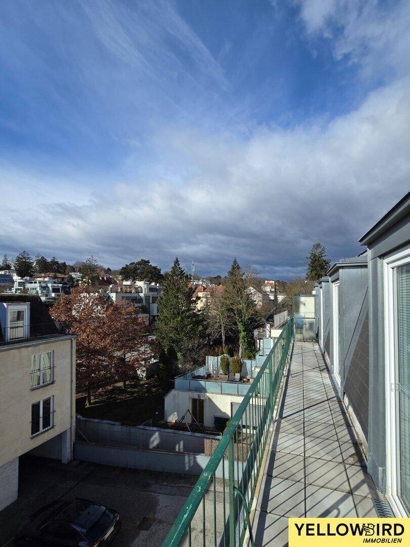 Geräumiger Balkon mit Blick auf die grüne Umgebung und die umliegenden Gebäude.