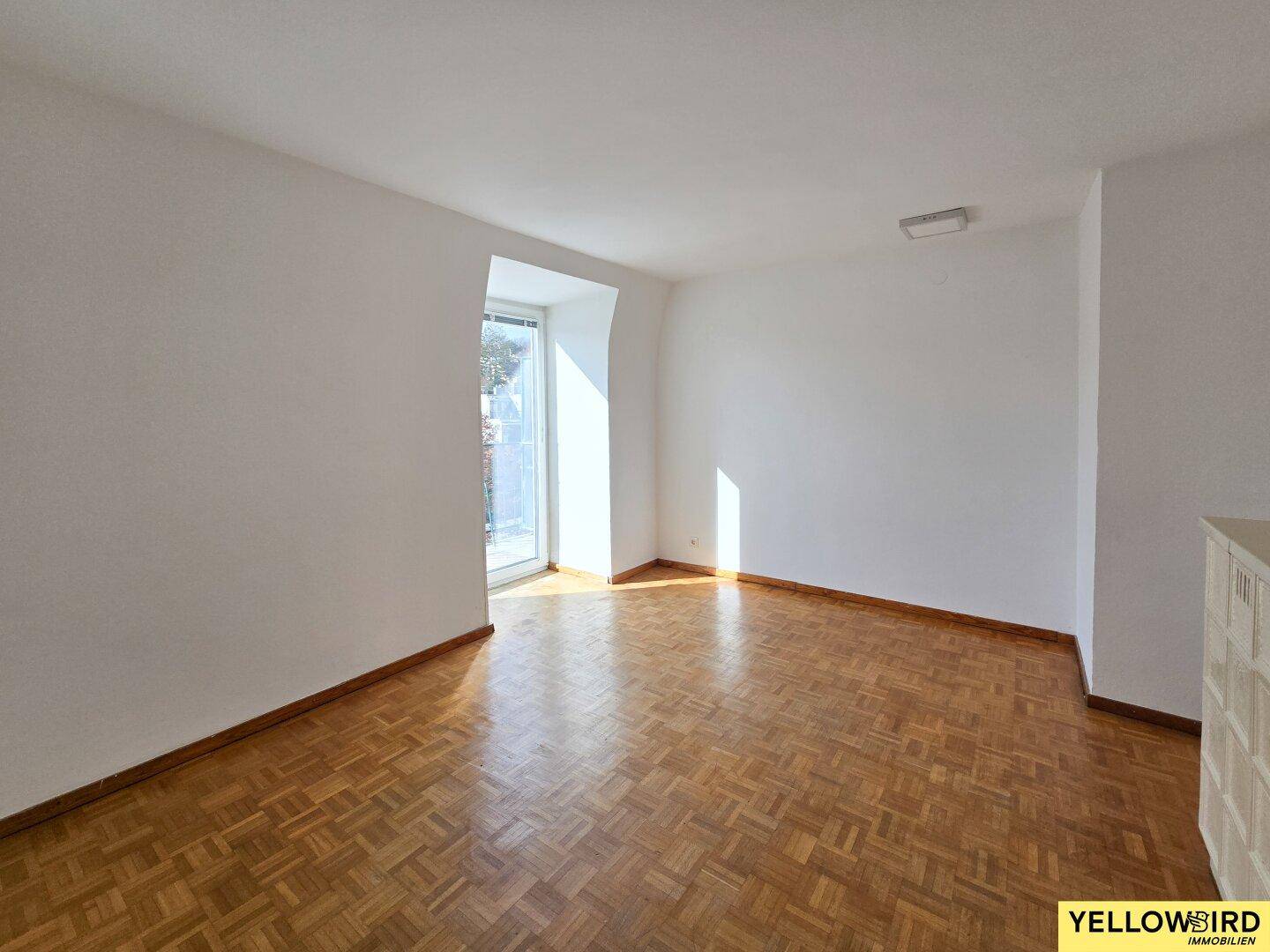 Geräumiges, helles Zimmer mit Parkettboden und viel Tageslicht.