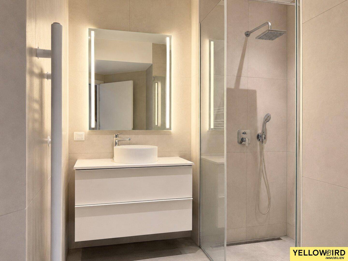Modernes Badezimmer mit begehbarer Dusche, beleuchtetem Spiegel und schwebendem Waschtisch.
