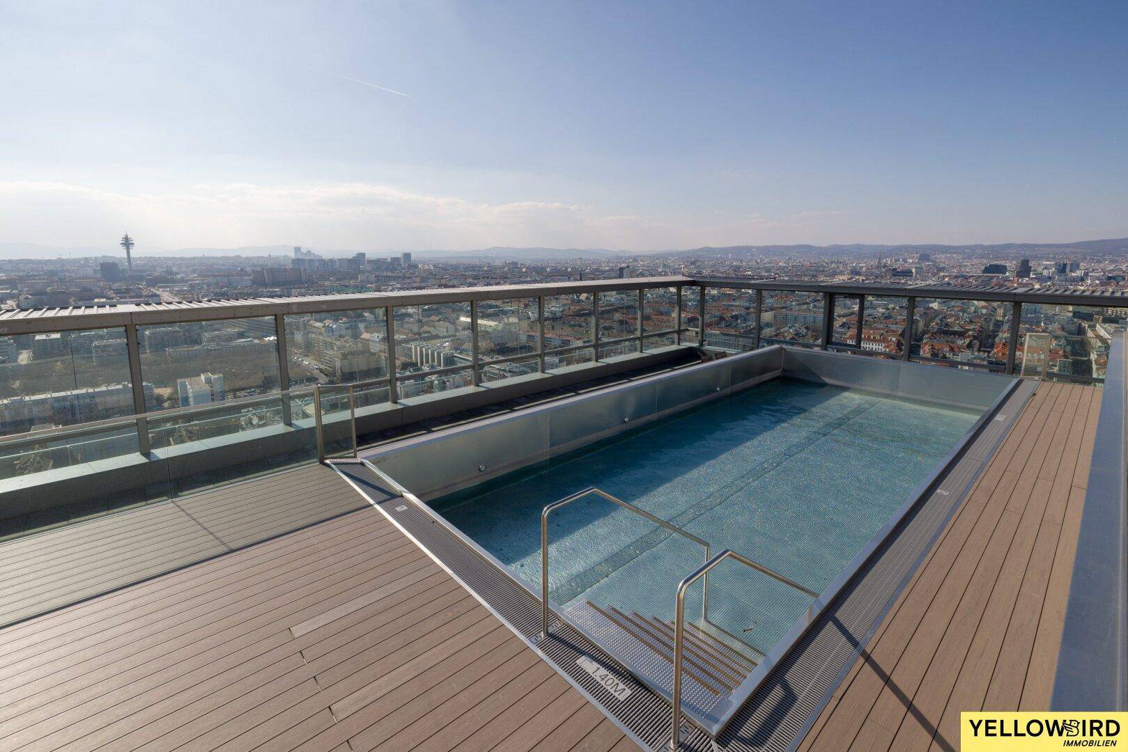 Integrierter Pool auf der Dachterrasse mit weitem Blick über die urbane Landschaft und den Himmel.