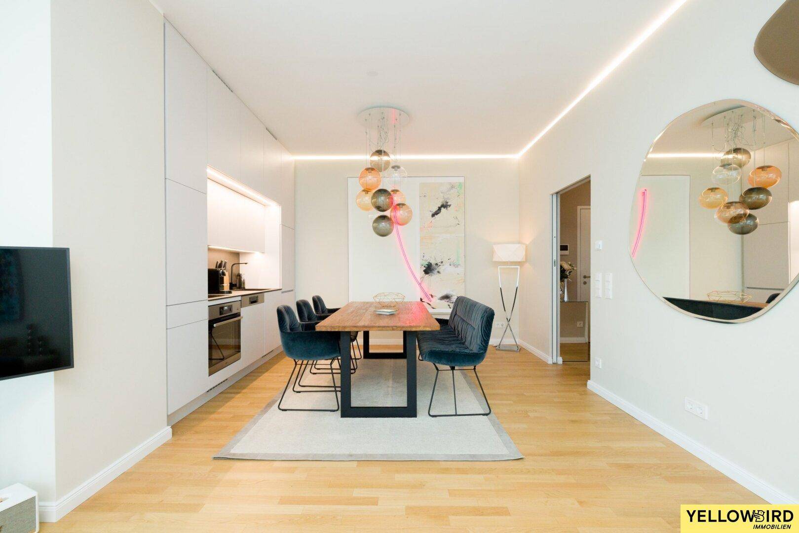 Offener Wohn-Essbereich mit integrierter Küche, Holztisch und modernem Design.