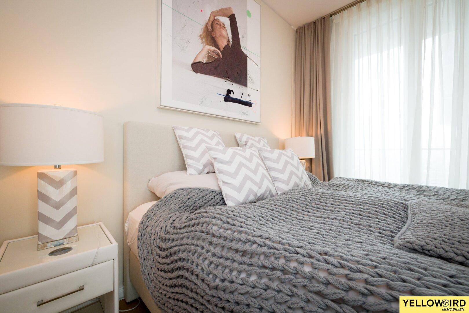 Gemütliches Schlafzimmer mit großem Bett, Nachttischen und dekorativen Kissen.