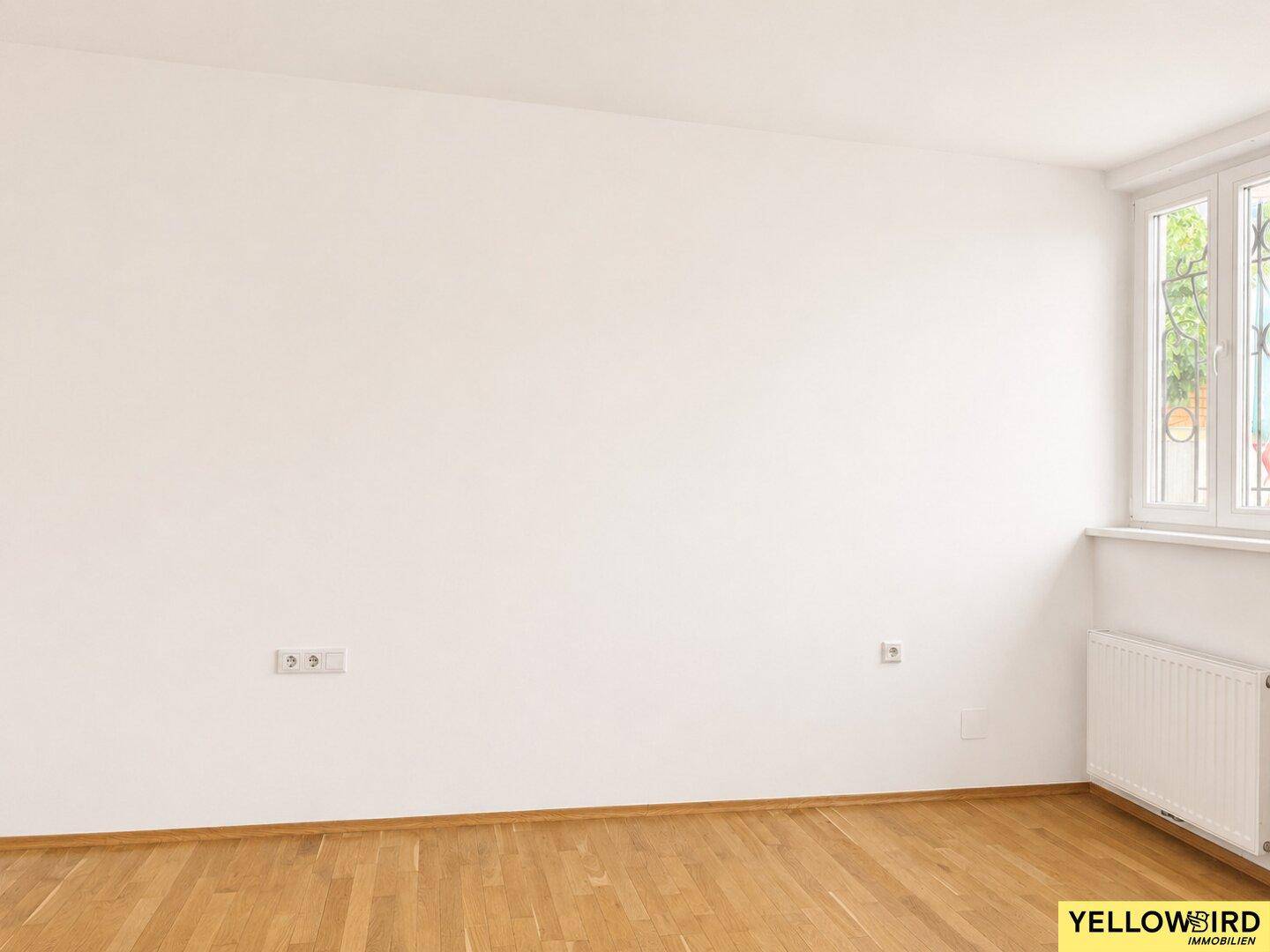 Geräumiges Schlafzimmer mit Holzboden und einem Fenster, das für eine angenehme Helligkeit sorgt.