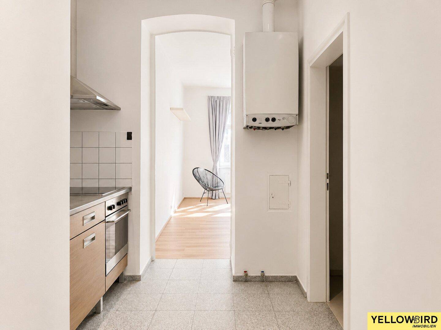 Küche mit Heiztherme und Durchgang zum hellen Wohnbereich.