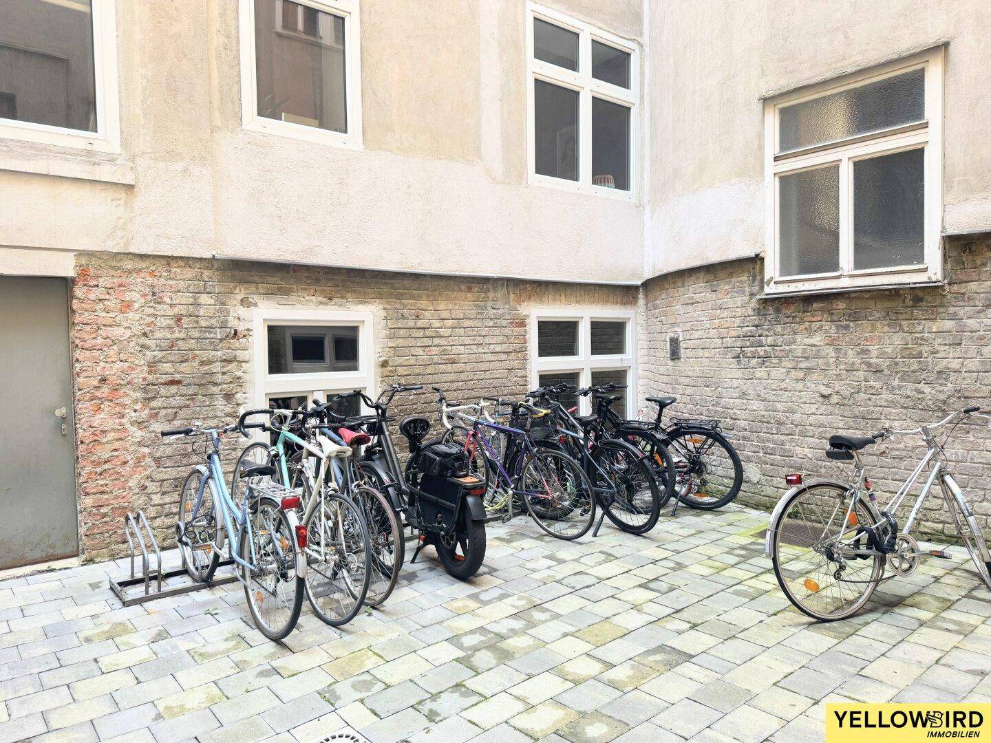 Innenhof mit Fahrradabstellplätzen und Backsteinwänden.