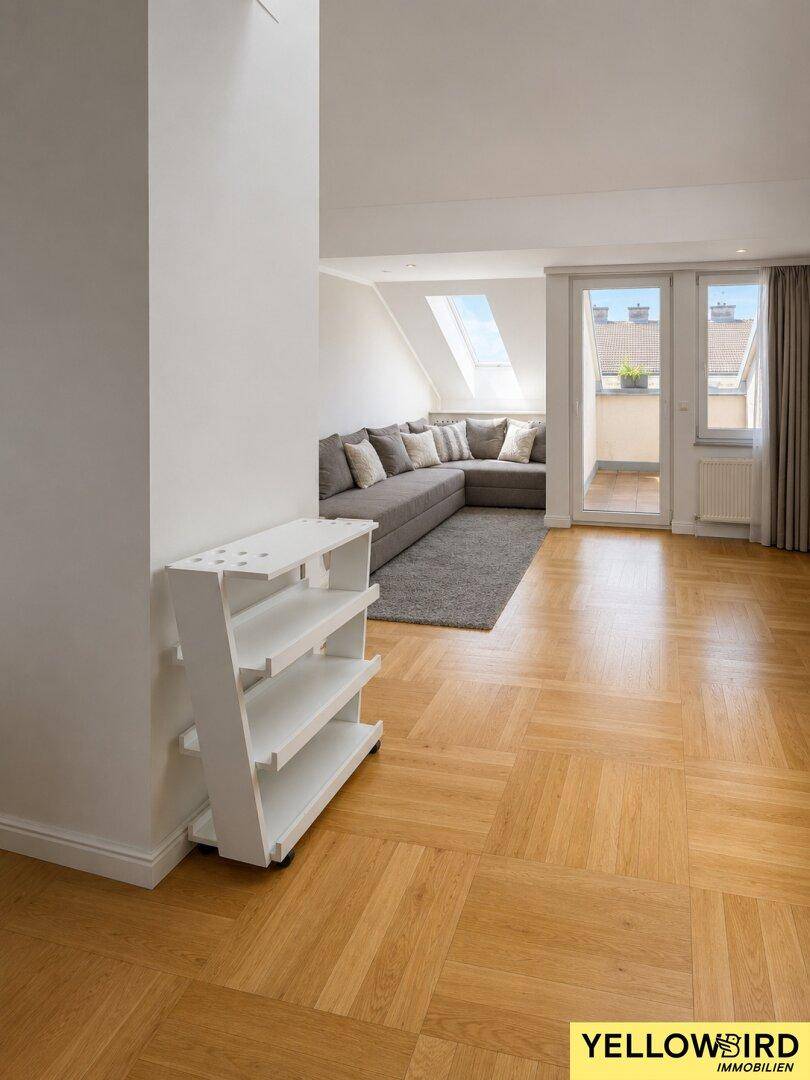 Heller Wohnbereich mit Holzparkett und Zugang zu einem kleinen Außenbereich, ideal zum Entspannen.