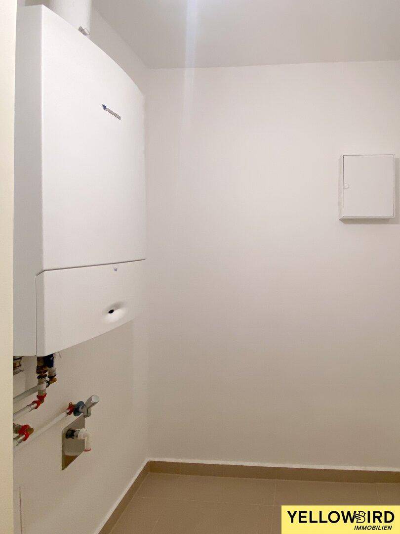 Praktischer Hauswirtschaftsraum mit Heizungsanlage und Fliesenboden, bietet zusätzlichen Stauraum.