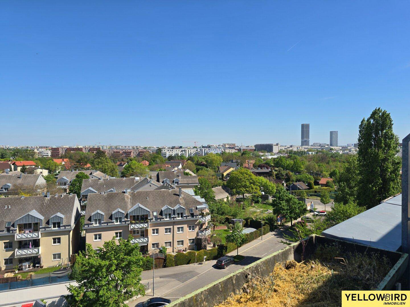 Panoramablick über die Stadtlandschaft mit Wohngebäuden und grünen Flächen.